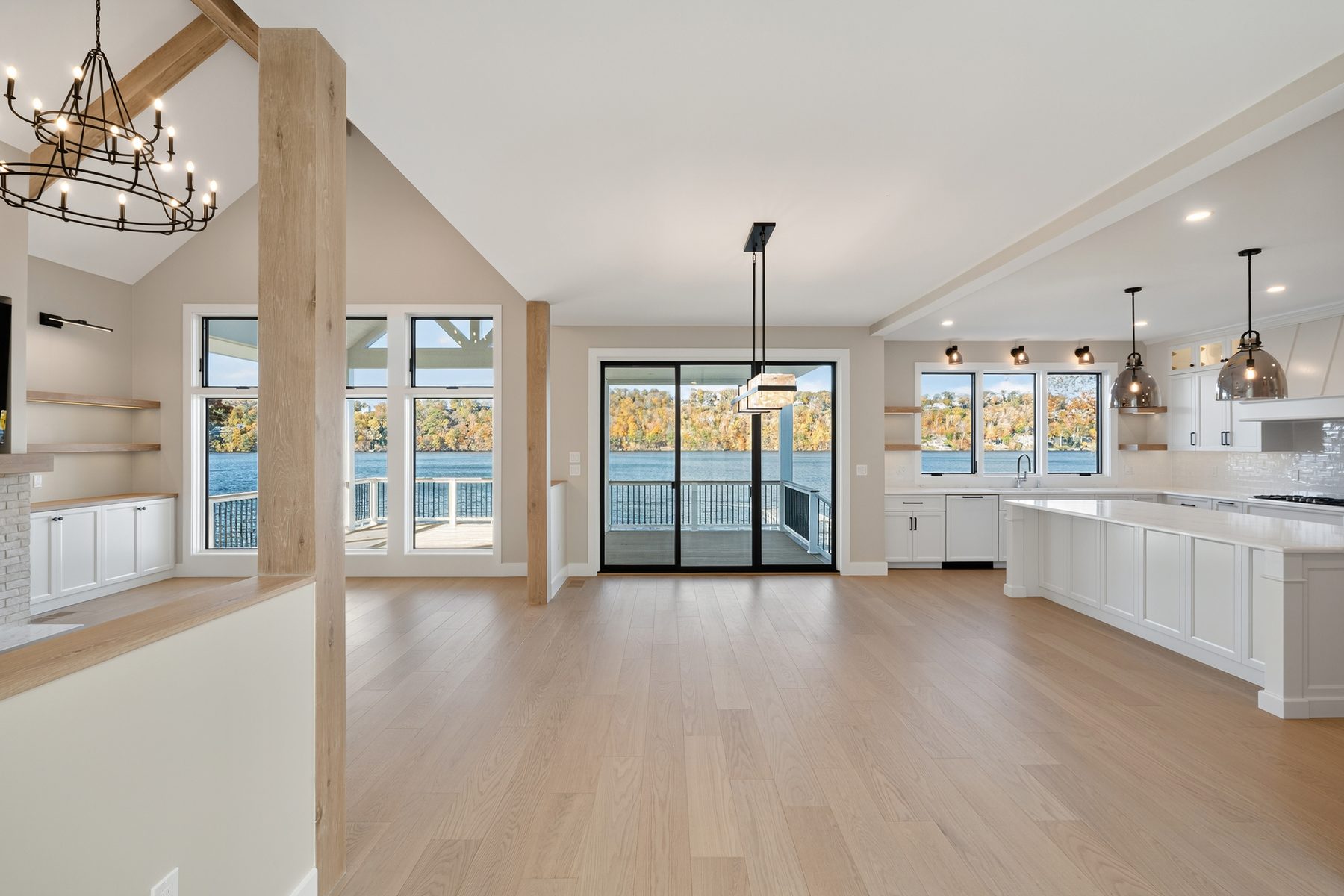 Open great room flowing into the lower kitchen beneath a wall of windows facing the lake - 148 North Lake Shore, a custom lakefront home in Candlewood Shores on Candlewood Lake