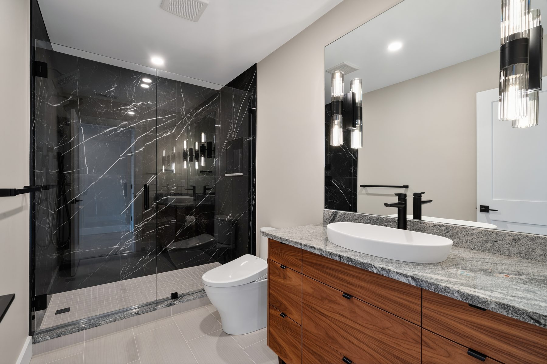 Guest bath with a dramatic black marble walk-in shower, walnut floating vanity, and stone-topped vessel sink - 148 North Lake Shore, a custom lakefront home in Candlewood Shores on Candlewood Lake