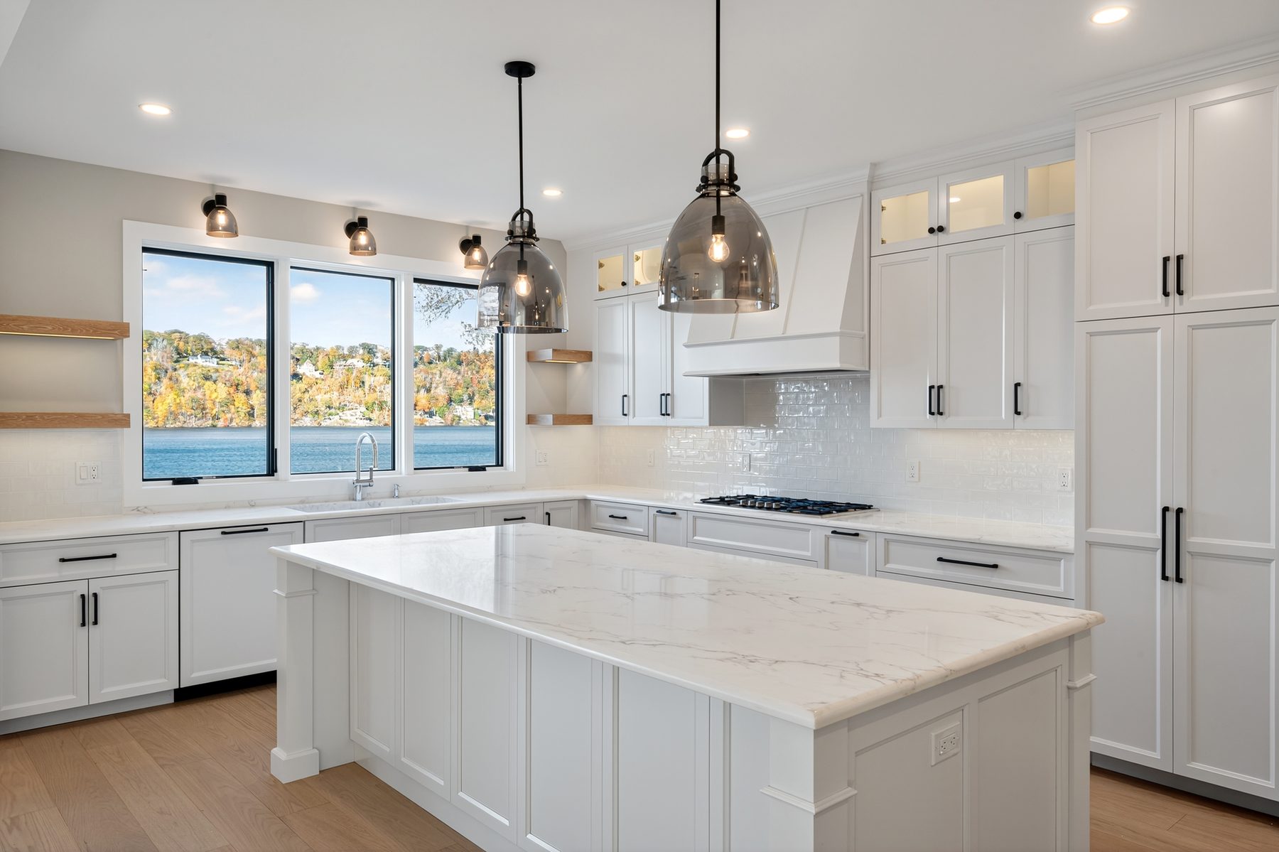 White upper kitchen viewed from the great room, with pendant lighting, open shelving, and a full-height pantry cabinet - 148 North Lake Shore in Candlewood Shores on Candlewood Lake