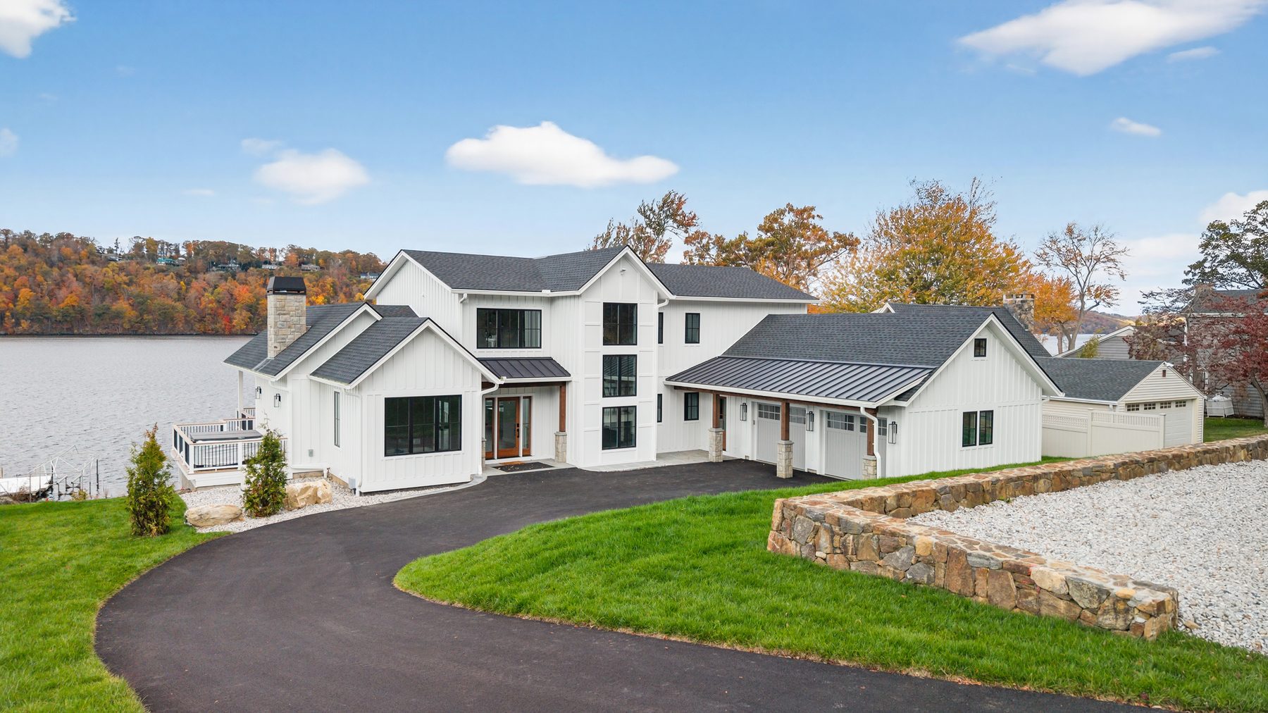 High aerial of the property's driveway approach and grounds against the backdrop of Candlewood Lake - 148 North Lake Shore in Candlewood Shores