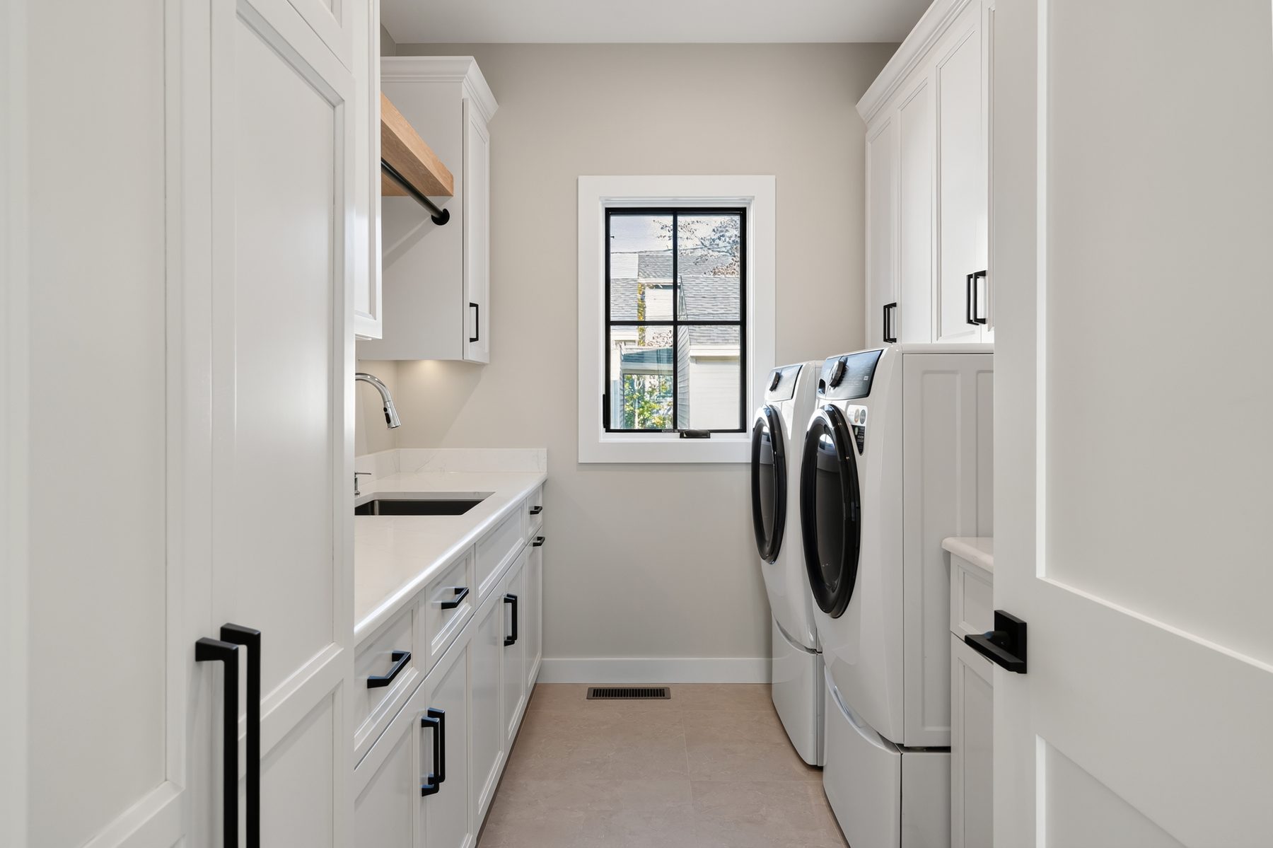 Laundry room with white cabinetry, a quartz counter and sink, and a side-by-side front-load washer and dryer - 148 North Lake Shore in Candlewood Shores on Candlewood Lake