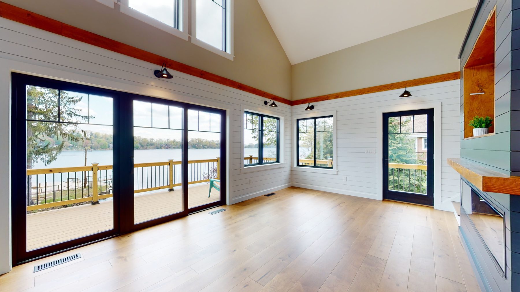 Vaulted great room with white shiplap, exposed wood beams, a built-in window seat and a wall of lake-view doors — 3 Woods Road, a custom lakefront home in Candlewood Knolls on Candlewood Lake