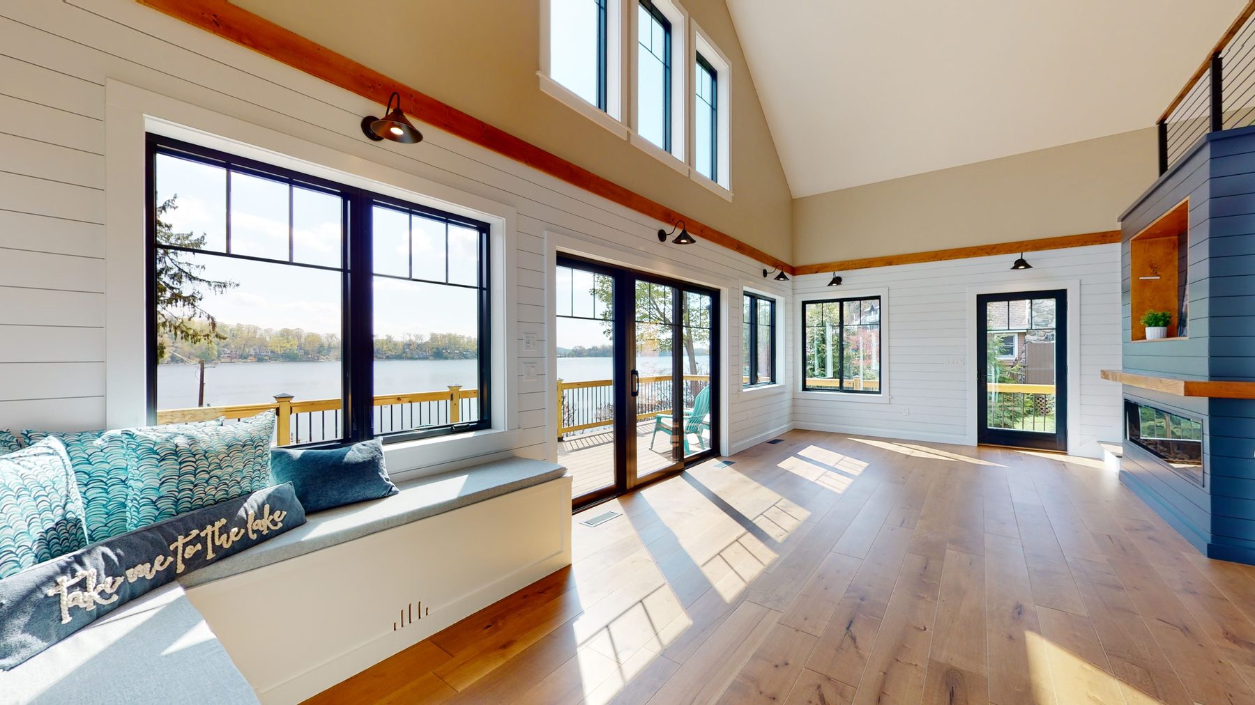 Great room window seat beneath black-trimmed windows framing wide-open views across Candlewood Lake — 3 Woods Road, a custom lakefront home in Candlewood Knolls on Candlewood Lake