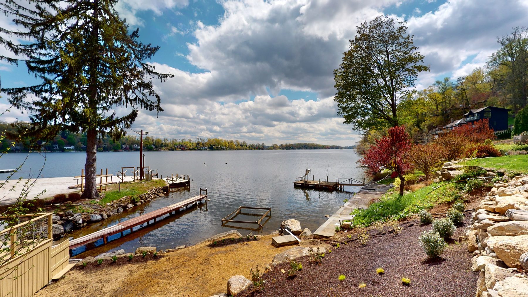 Landscaped lakefront shoreline with private docks looking down the open water of Candlewood Lake — 3 Woods Road, a custom lakefront home in Candlewood Knolls on Candlewood Lake