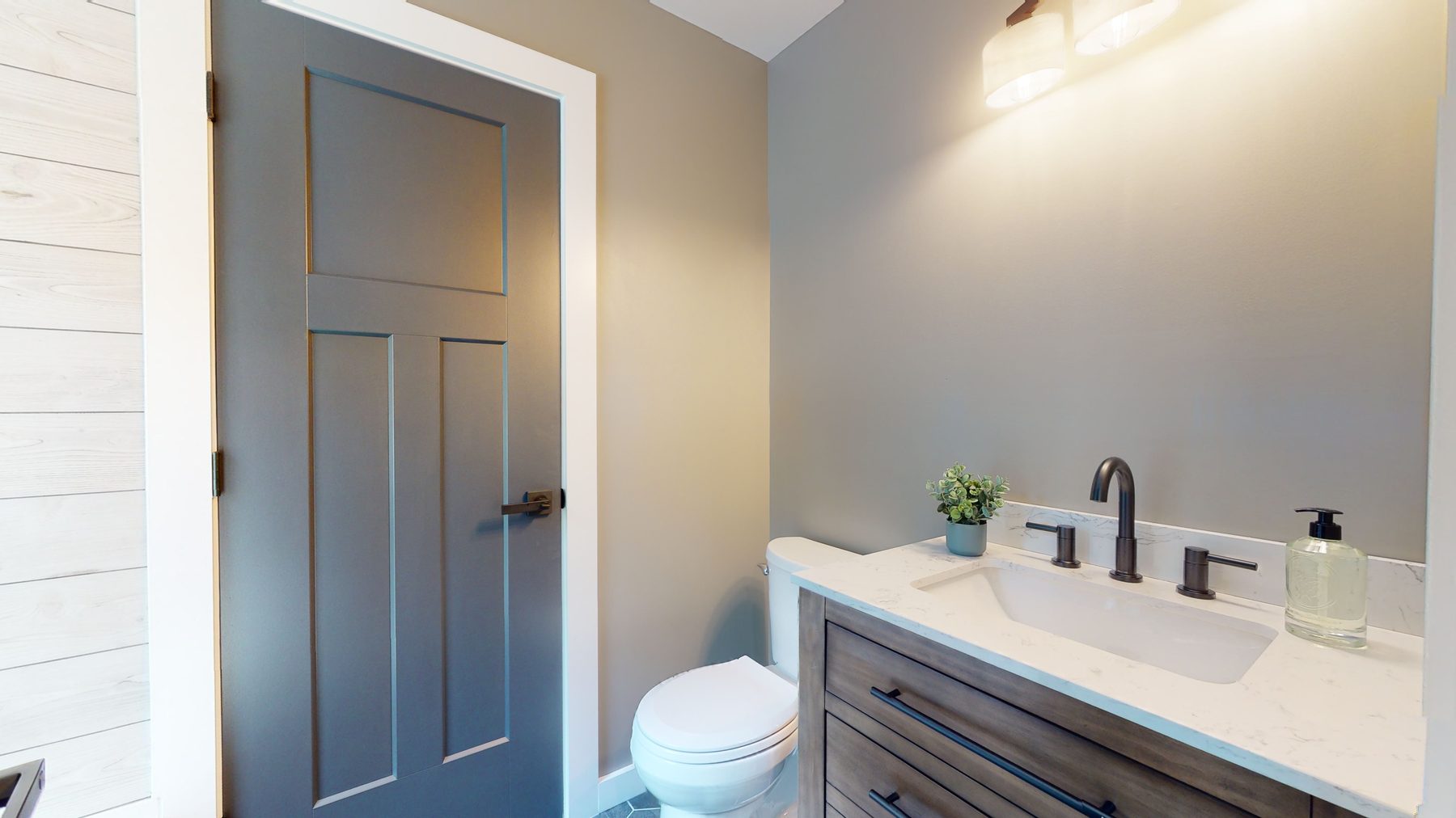 Powder room with a wood vanity, marble-look quartz counter, undermount sink and a gray shaker door — 3 Woods Road, a custom lakefront home in Candlewood Knolls on Candlewood Lake