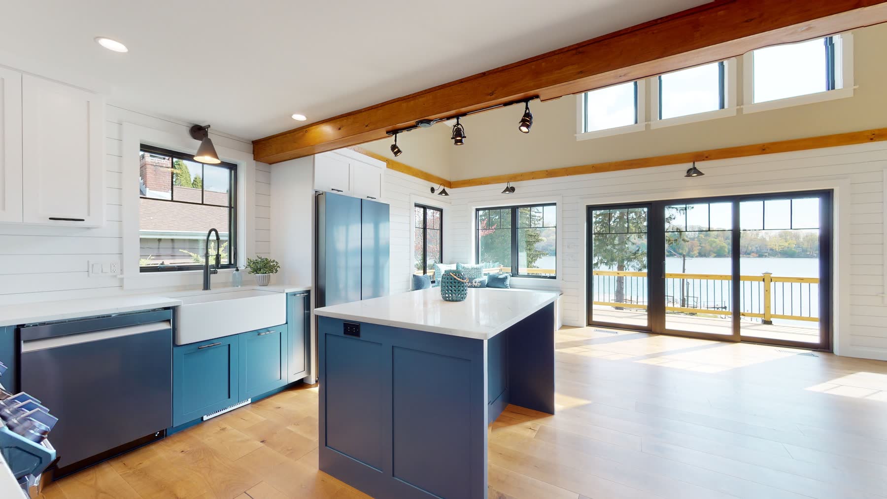 Open kitchen at 3 Woods Road with a navy island, farmhouse sink and clerestory windows framing the lake view — custom home by Bulldog Enterprises in Candlewood Knolls