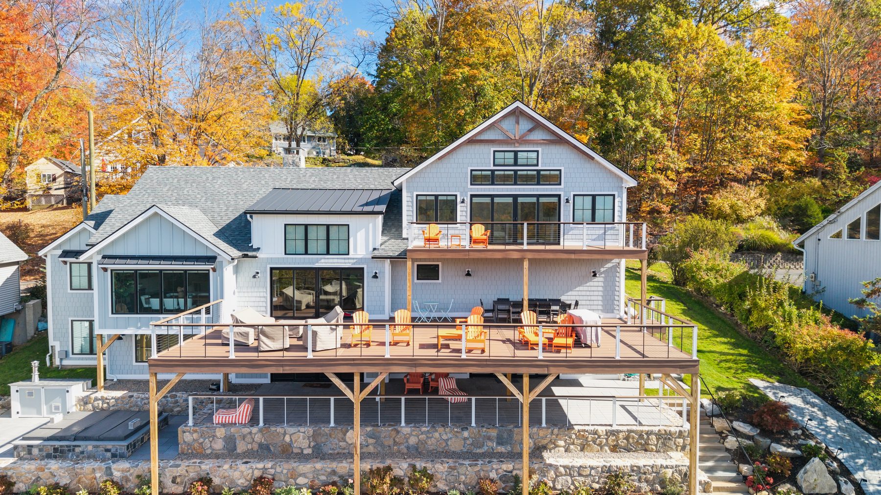 Aerial view of the lakeside rear elevation with multi-level decks and fall foliage - 43 Moody Lane, a custom home in Danbury, CT