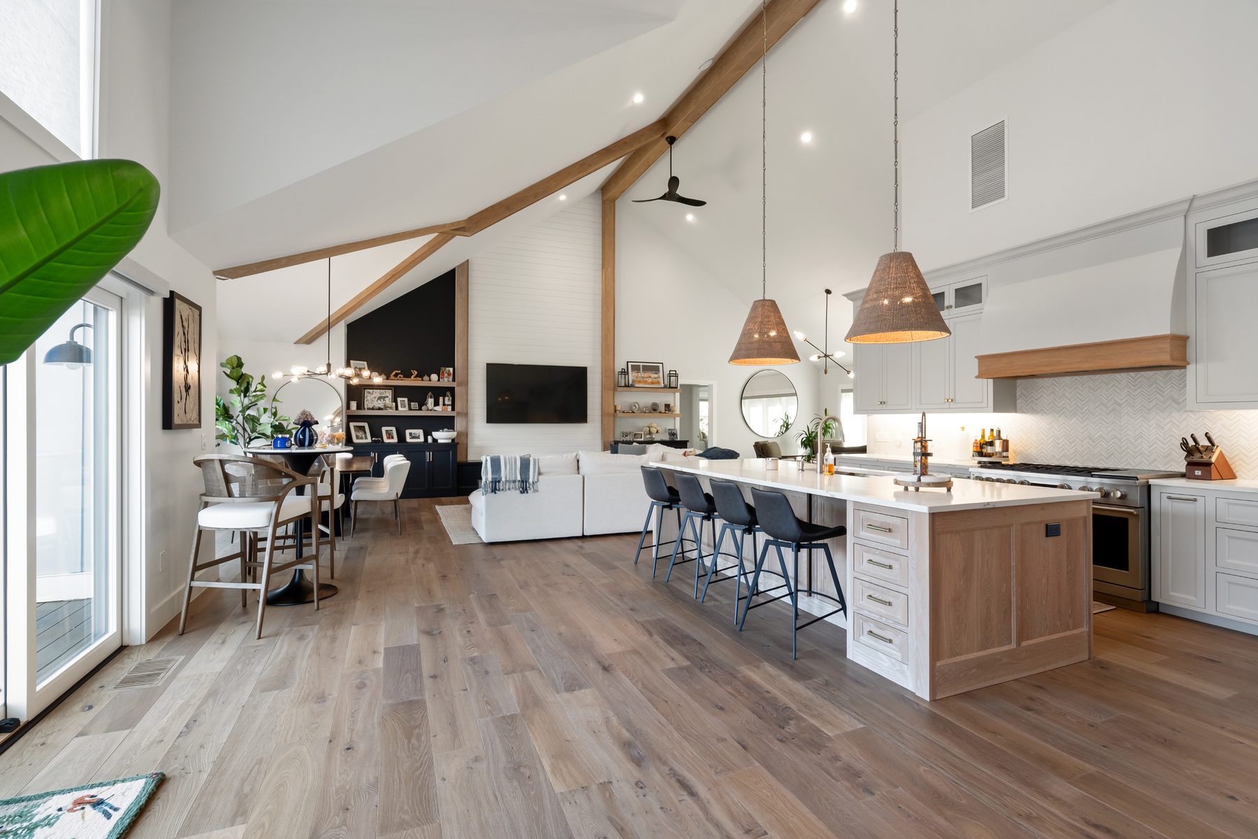 Open great room with vaulted ceiling, exposed wood beams and a white-oak kitchen island under woven pendants - 43 Moody Lane, a custom home in Danbury, CT