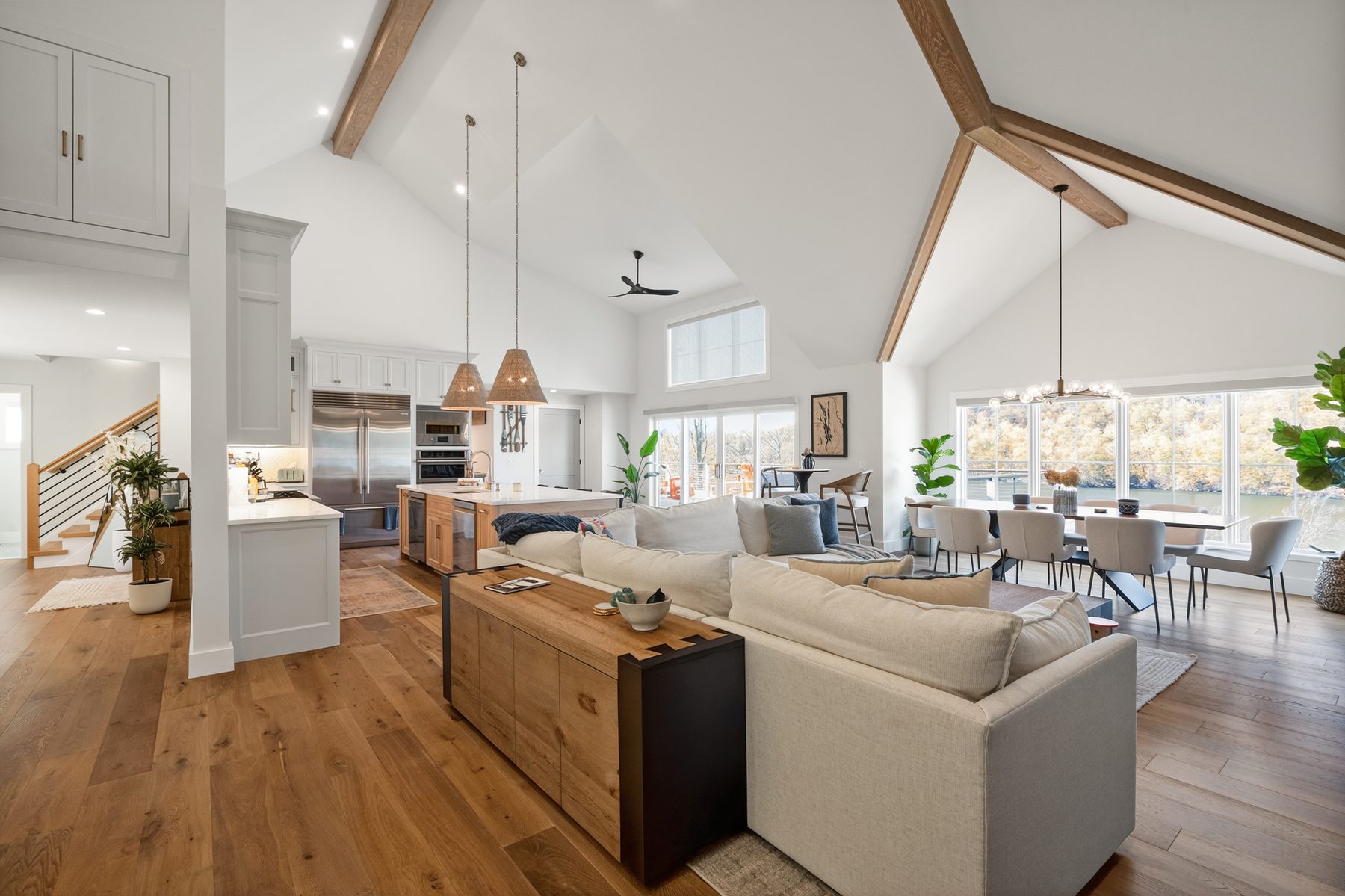 Great room viewed from the living side, sectional and dining flowing toward window-wall lake views - 43 Moody Lane, a custom home in Danbury, CT