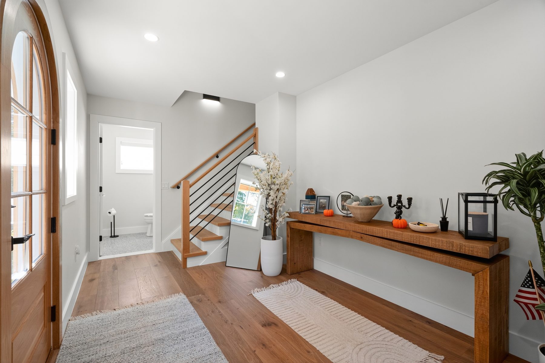 Entry foyer with an arched glass front door and an open-riser staircase with a slim cable railing - 43 Moody Lane, a custom home in Danbury, CT
