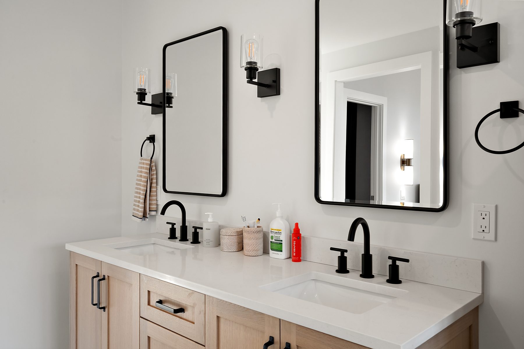 Bathroom double vanity in light oak with quartz top, black faucets and twin black-framed mirrors - 43 Moody Lane, a custom home in Danbury, CT