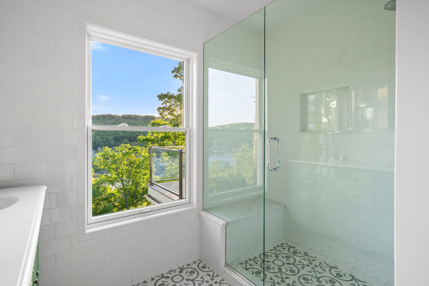 Master bath with glass shower, patterned mosaic floor and a picture window framing Candlewood Lake - 48 Ridge Road on Candlewood Isle