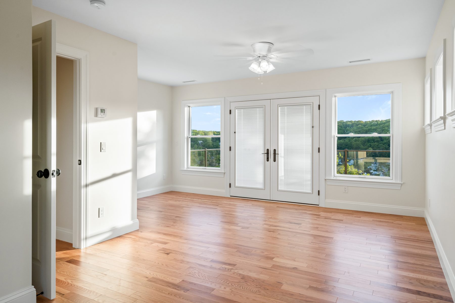 Upstairs bedroom opening through French doors and flanking windows to sweeping lake-and-hill views - 48 Ridge Road on Candlewood Isle